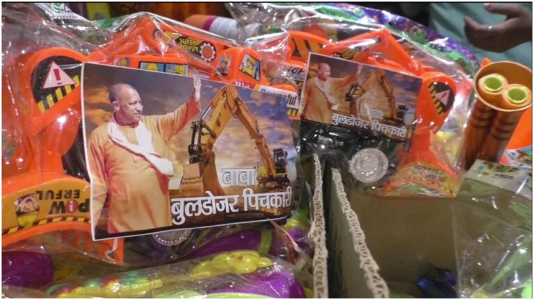 Uttar Pradesh : होली पर बुलडोजर पिचकारी की धूम, मोदी और योगी के मुखौटों के साथ मोदी दाढ़ी की बढ़ी मांग